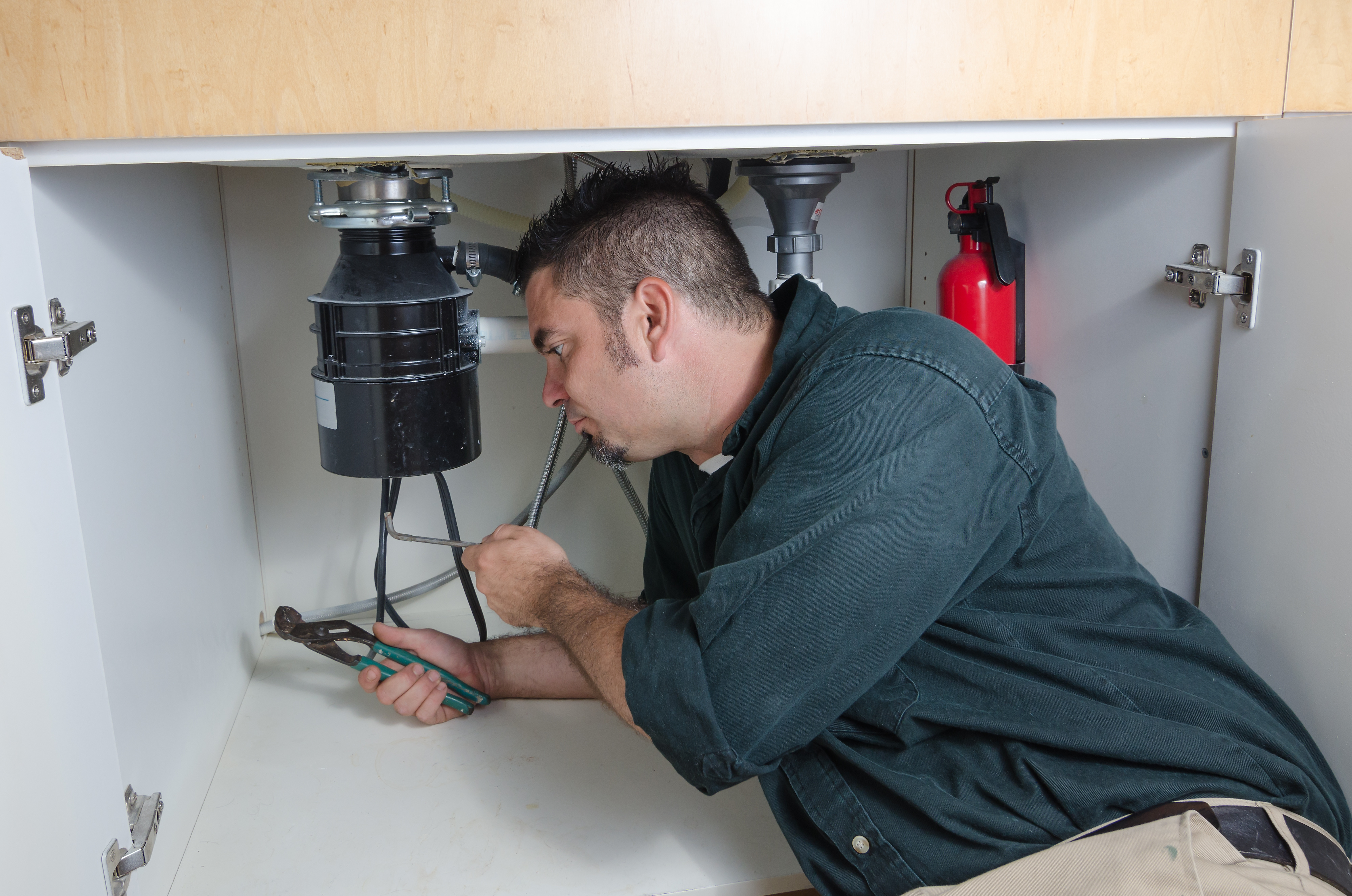 Plumber installing a garbage disposal