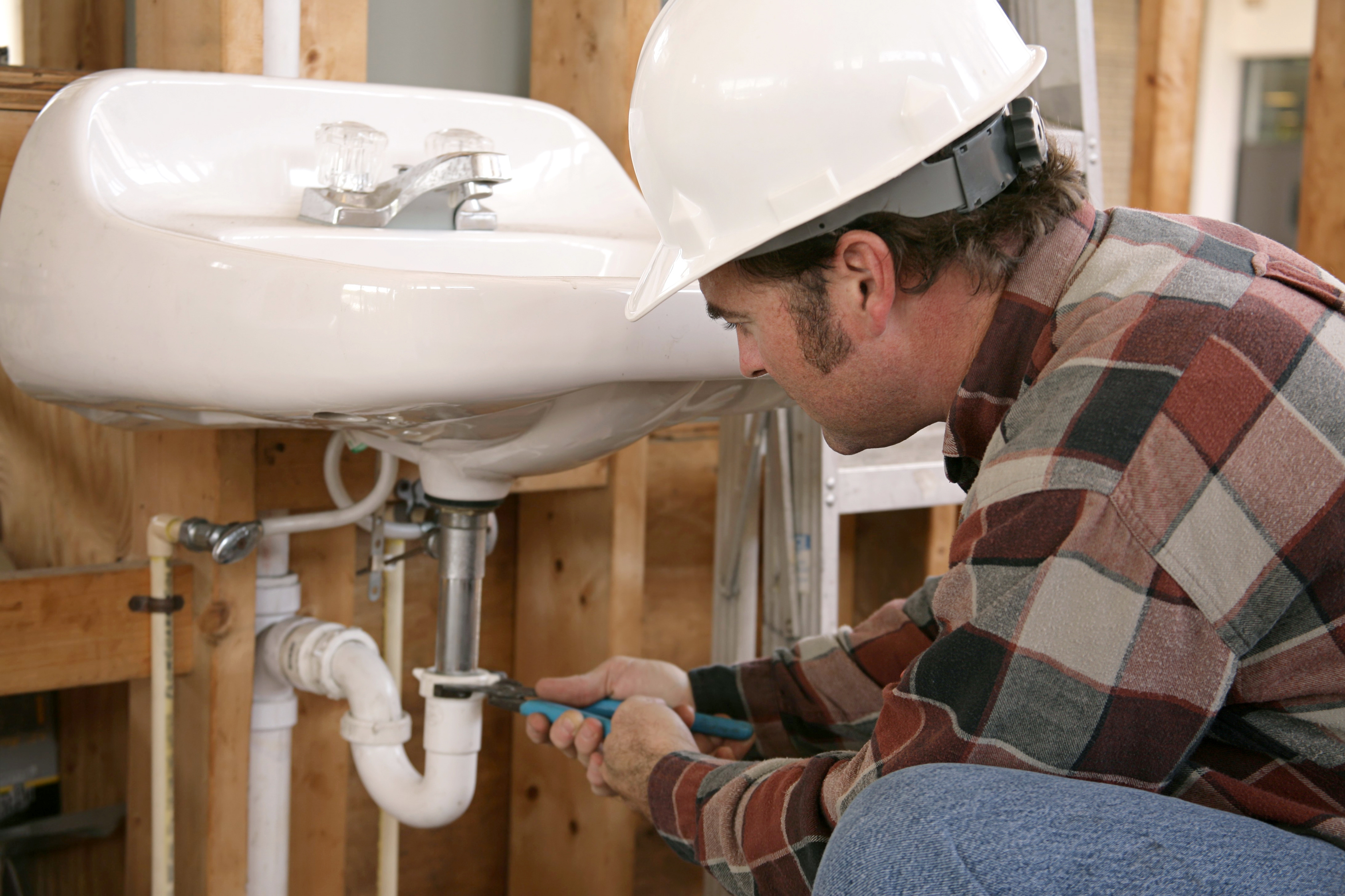 Plumber installing new plumbing in a new construction